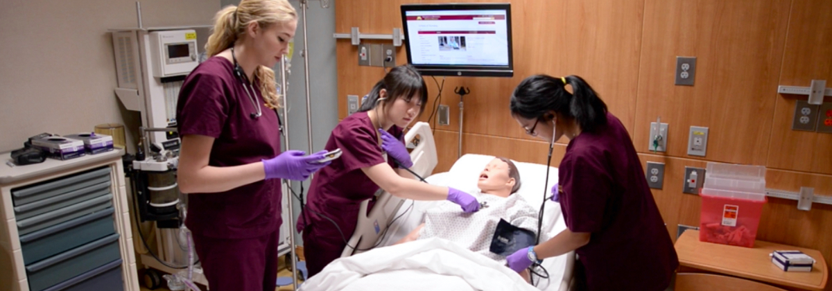 Nursing students assisting a simulation patient Manikin