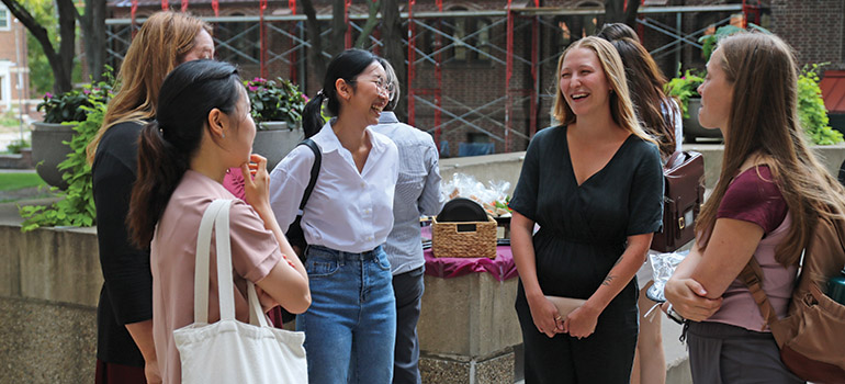 five female PhD students talking outside