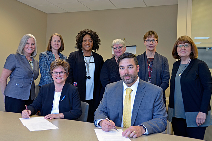 University of Minnesota School of Nursing and Saint Paul College leaders signing collaboratory documents