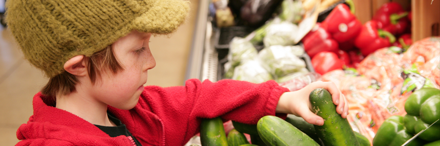 Boy choosing vegetables in grocery store