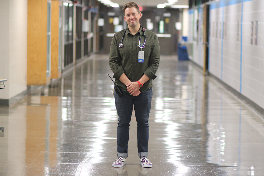 male medical professional with stethoscope around his neck in a hallway