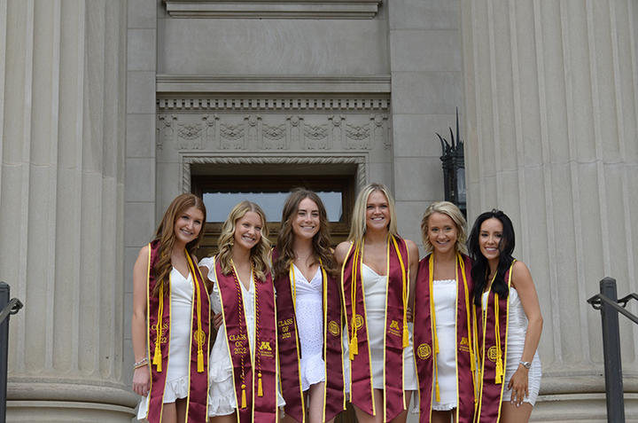 Six spring 2022 commencement honor graduates in white dresses on steps outside Northrop