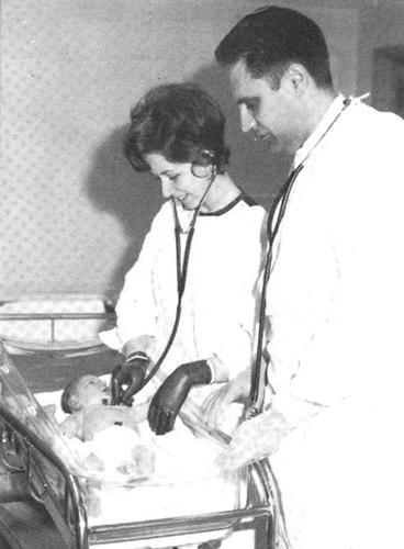 Doctor and nurse examining infant
